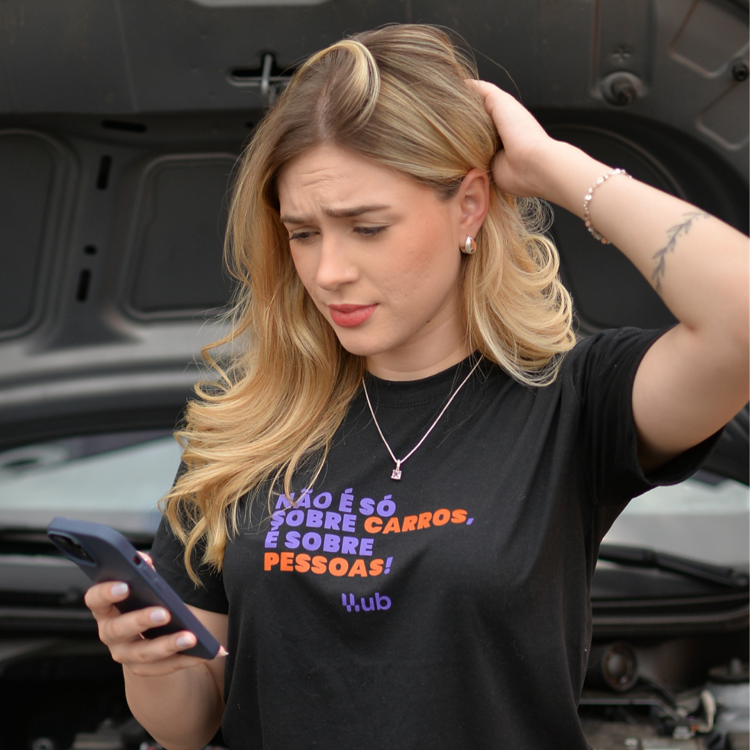 Associada da UB conferindo o app ao lado do carro
